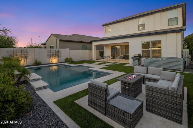 pool at dusk featuring a patio, an outdoor living space with a fire pit, and area for grilling