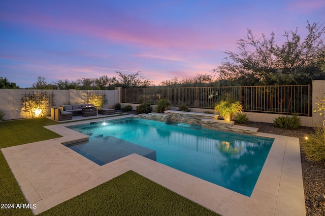 pool at dusk with a hot tub, an outdoor living space, pool water feature, and a patio