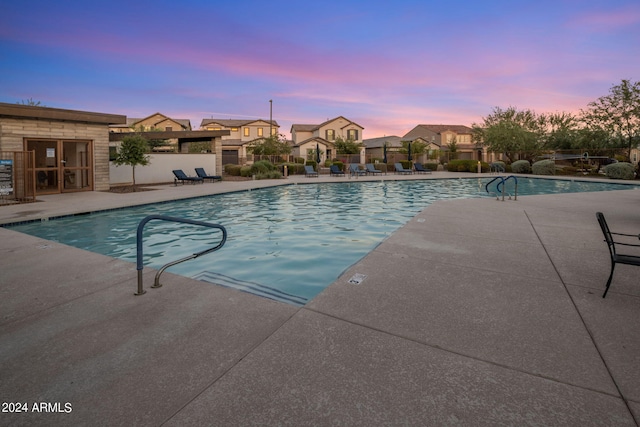 pool at dusk with a patio