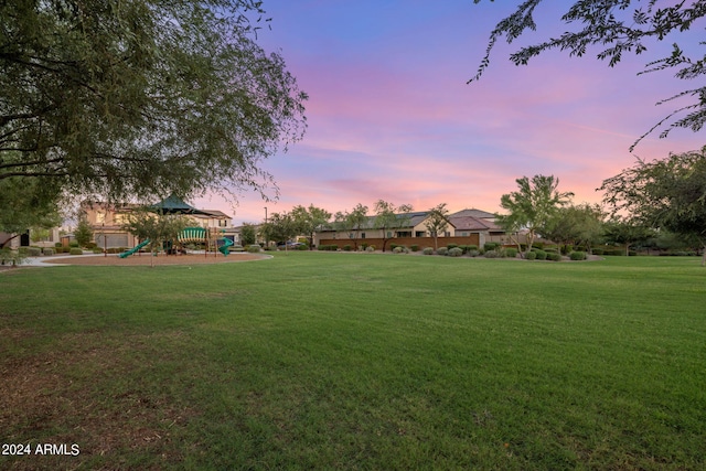 yard at dusk featuring a playground