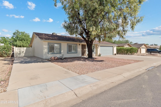 ranch-style house with concrete driveway, an attached garage, and stucco siding