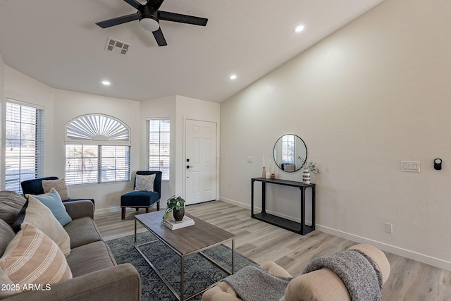 living room with ceiling fan, light wood-type flooring, and vaulted ceiling