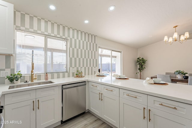 kitchen with sink, hanging light fixtures, white cabinets, and dishwasher