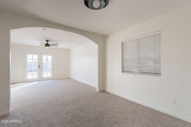 spare room with ceiling fan, french doors, and carpet