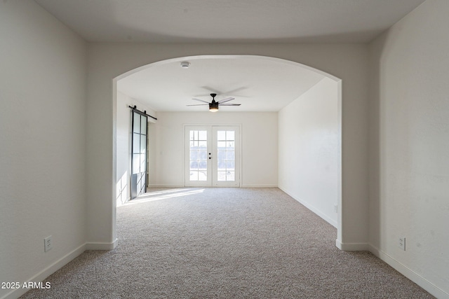 carpeted empty room with ceiling fan and french doors