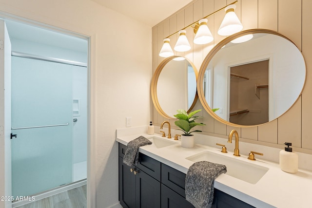 bathroom featuring vanity and a shower with door