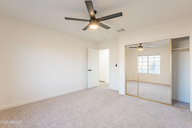 unfurnished bedroom with ceiling fan, carpet, and a closet