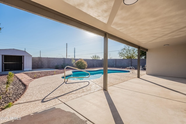 view of pool with a storage shed and a patio