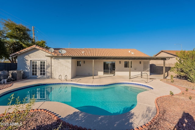 view of pool featuring a patio area, central AC unit, and french doors