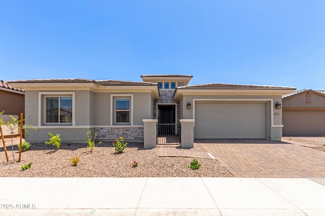 11015 E Texas Ave, Mesa, AZ 85212 - prairie-style house featuring decorative driveway, an attached garage, stucco siding, and a tiled roof