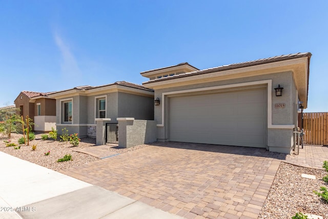 11015 E Texas Ave, Mesa, AZ 85212 - prairie-style home featuring stucco siding, decorative driveway, a gate, and a garage