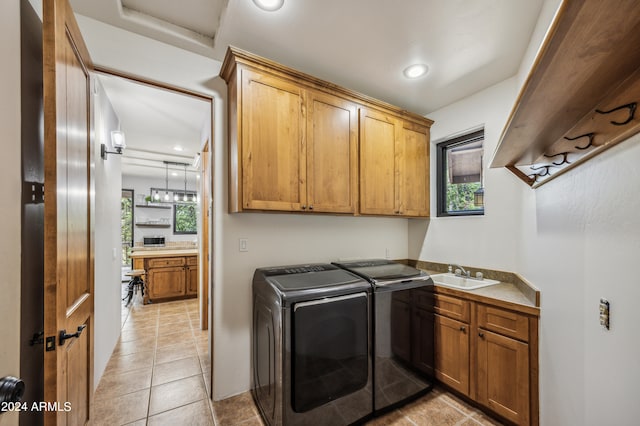 laundry room featuring sink, cabinets, light tile patterned floors, and independent washer and dryer