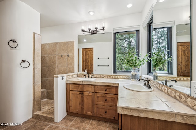 bathroom featuring tile patterned floors, independent shower and bath, double vanity, and a wealth of natural light