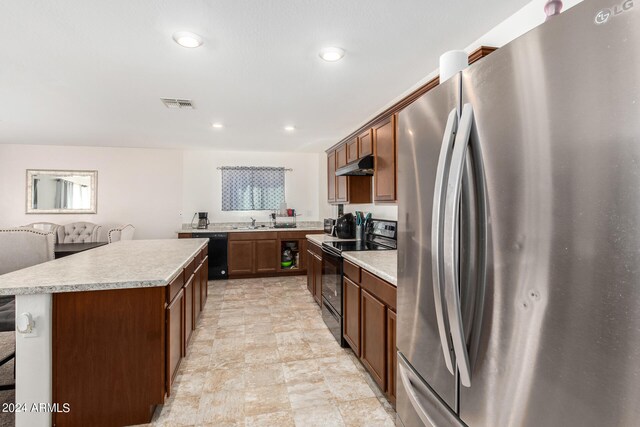 kitchen with black appliances, a center island, and sink