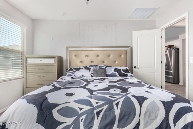 bedroom with carpet floors and stainless steel refrigerator