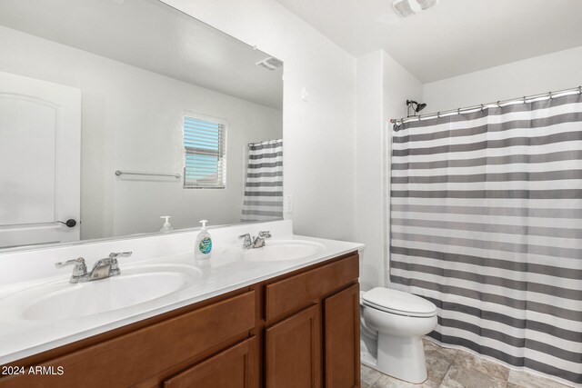 bathroom featuring vanity, toilet, and curtained shower