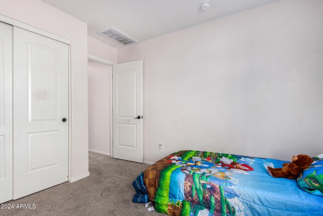 bedroom with light carpet and a closet