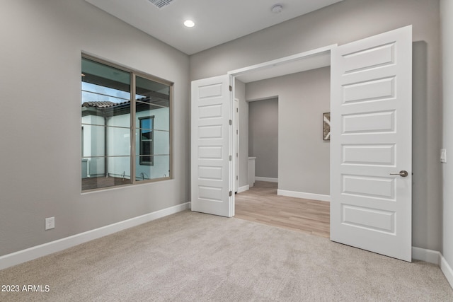 unfurnished room with light colored carpet