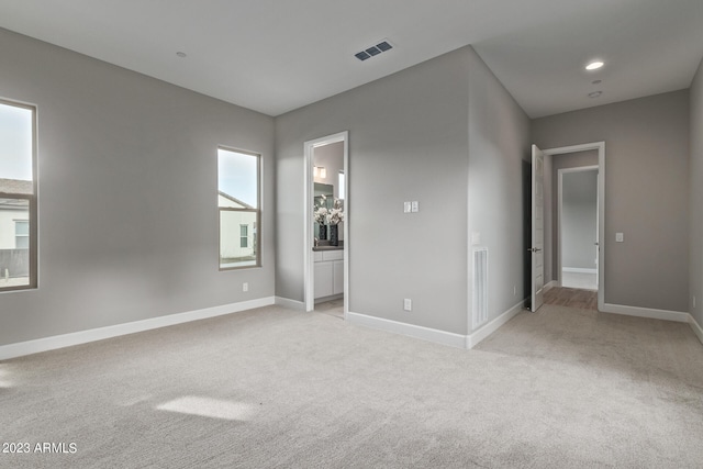 unfurnished bedroom with light colored carpet and ensuite bathroom