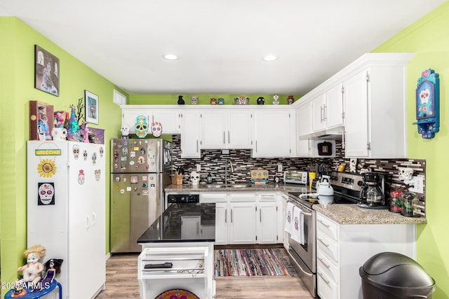 kitchen featuring white cabinetry, sink, light stone countertops, tasteful backsplash, and appliances with stainless steel finishes