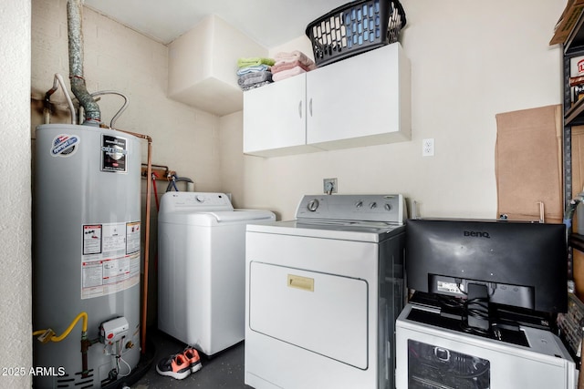 washroom featuring water heater, washer and dryer, and cabinets