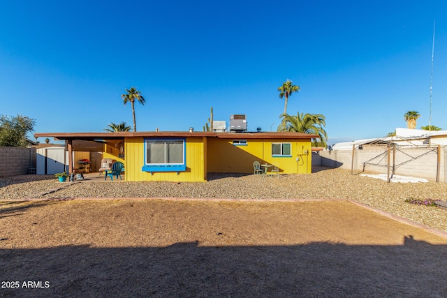 view of front of property featuring central AC and a carport