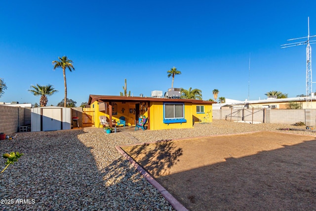 rear view of house featuring a storage unit