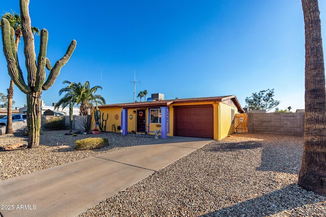 single story home featuring central AC unit and a garage