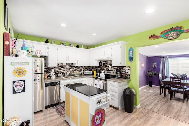 kitchen featuring stainless steel appliances, sink, light hardwood / wood-style flooring, a center island, and white cabinetry