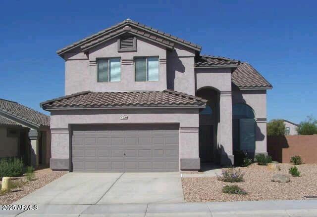 view of front of house with driveway, a tiled roof, and stucco siding