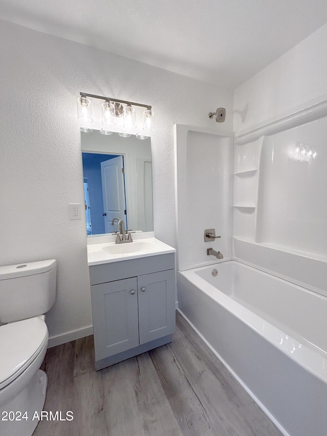 full bathroom with hardwood / wood-style floors, vanity, shower / bath combination, and toilet