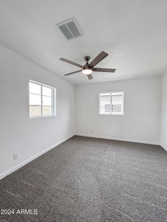 spare room featuring ceiling fan, carpet, and a textured ceiling