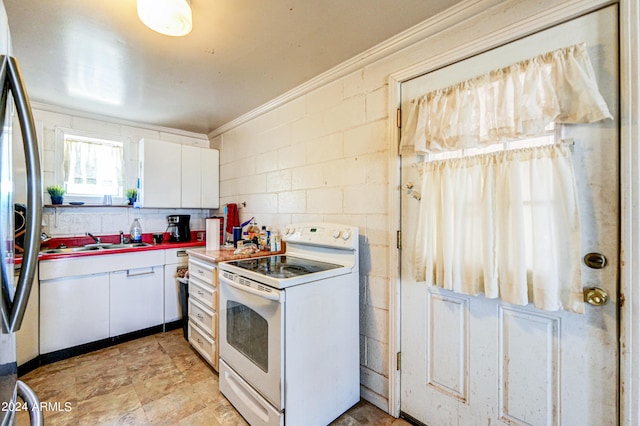 kitchen with stainless steel refrigerator, sink, white cabinets, and white electric range oven