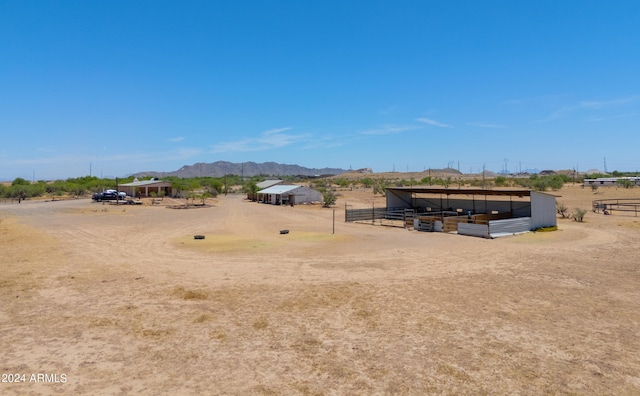 view of yard featuring a mountain view, a rural view, and an outdoor structure