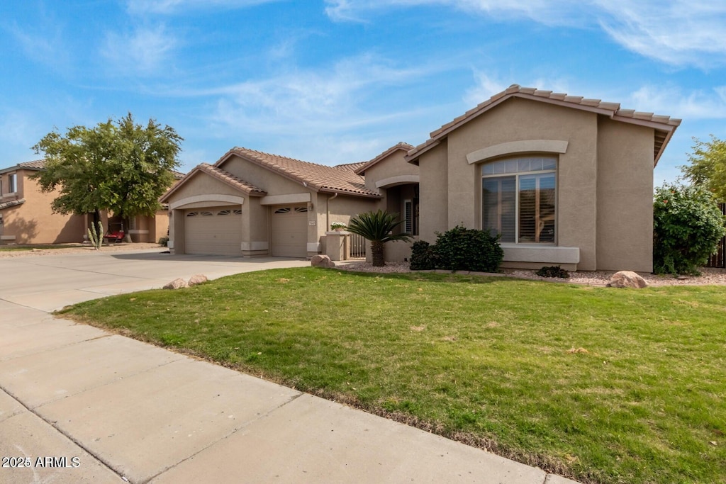 mediterranean / spanish-style house featuring a garage and a front lawn