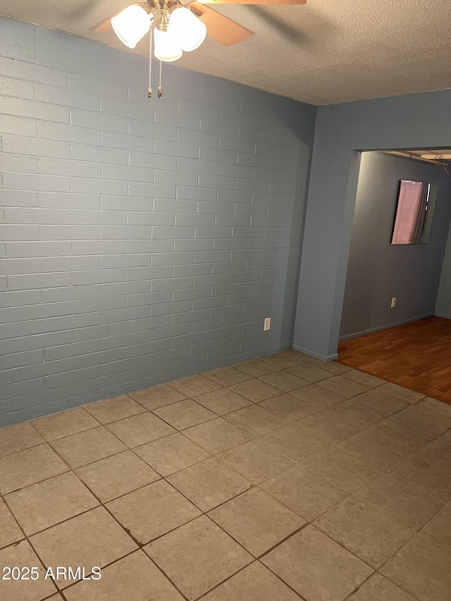 unfurnished room featuring a ceiling fan and a textured ceiling