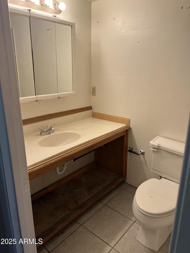 bathroom with toilet, tile patterned floors, and vanity