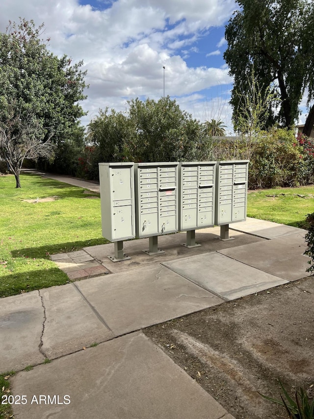 view of property's community featuring a lawn and mail area