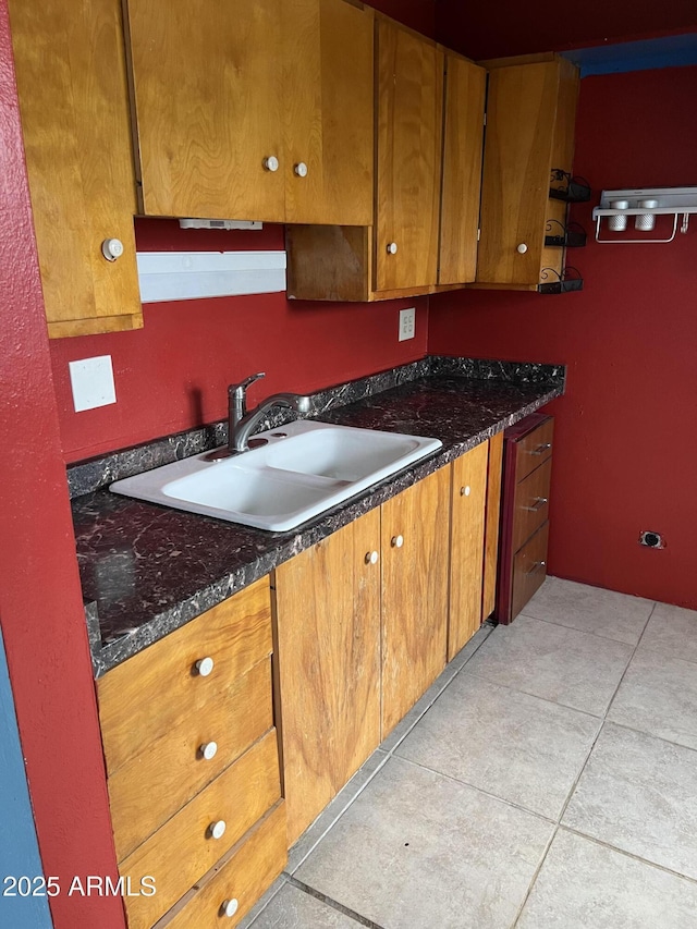 kitchen featuring brown cabinets, a sink, and light tile patterned floors