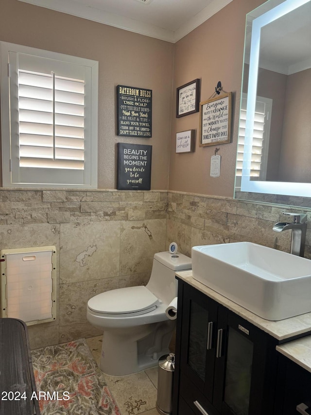 bathroom with vanity, toilet, tile walls, and crown molding