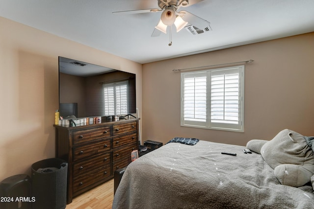 bedroom with light wood-type flooring, multiple windows, and ceiling fan