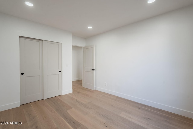 unfurnished bedroom with light wood-style floors, baseboards, a closet, and recessed lighting