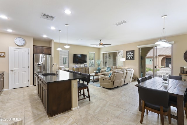 kitchen featuring a sink, dark brown cabinetry, visible vents, and ceiling fan