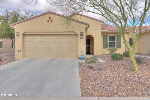 mediterranean / spanish home with stucco siding, driveway, an attached garage, and a tile roof