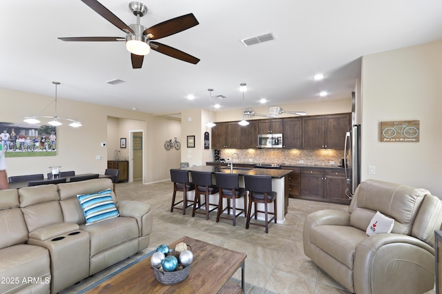 living area featuring recessed lighting, visible vents, and a ceiling fan