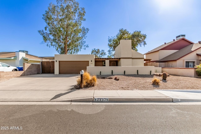 view of front of home with a garage, driveway, fence, and stucco siding