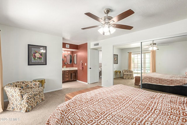 bedroom with a closet, visible vents, light carpet, connected bathroom, and baseboards