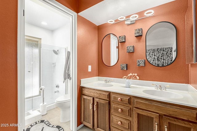 full bath featuring double vanity, a stall shower, tile patterned flooring, and a sink