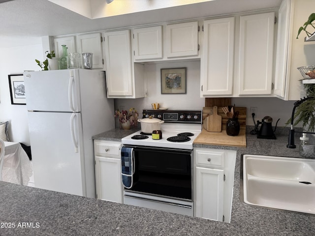 kitchen with white fridge, white cabinets, range with electric stovetop, and sink