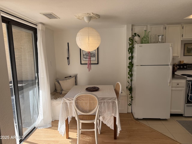 dining room featuring a wealth of natural light and light hardwood / wood-style flooring